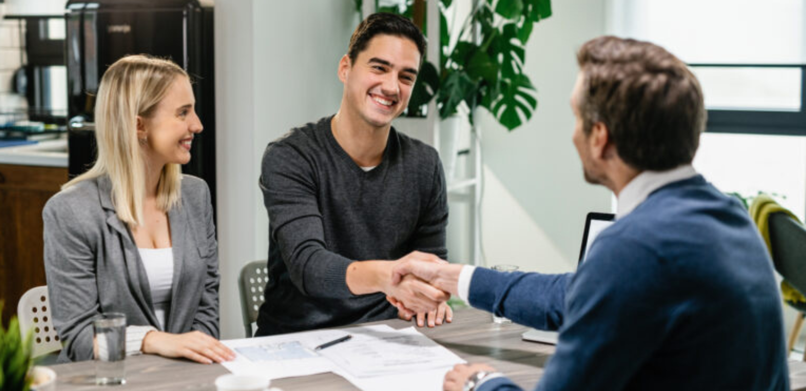 un couple heureux concluant un accord avec un banquier